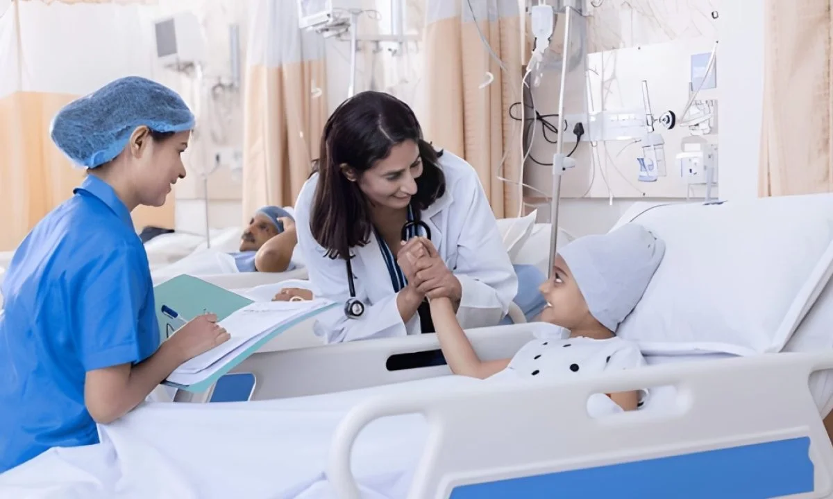 A doctor and nurse caring for a young cancer patient at an OIATI-supported facility